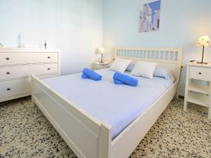 库尼特Apartment Costa Playa by Interhome的白色卧室配有一张带蓝色枕头的大床