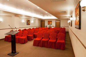 迪拜置地广场酒店 的一间会议室,配有红色椅子和讲台