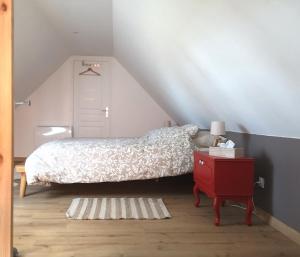 Ennetières-en-WeppesGîte de la Carnoy的一间卧室配有一张床和一个红色的床头柜