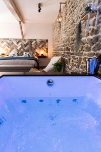 LongmesnilLa Suite de l'Etoile的石墙房间内的热水浴缸