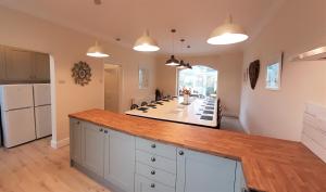 本莱赫Woodlands的厨房配有白色橱柜和木制台面