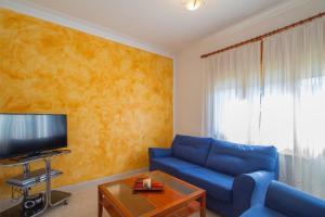 卡隆赫Club Villamar - Ruizman的客厅配有蓝色的沙发和电视