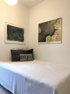 哥本哈根ApartmentInCopenhagen Apartment 1440的卧室内的一张床铺,墙上有两张照片