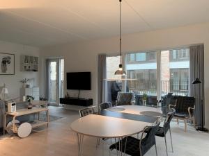 哥本哈根ApartmentInCopenhagen Apartment 1440的客厅配有桌椅和电视。