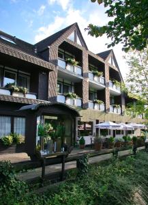伦讷施塔特拉尔曼兰德酒店的前面有盆栽植物和雨伞的建筑