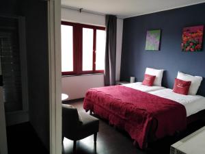 胡法利兹毕多雷斯基床和早餐的一间卧室配有两张床和红色毯子