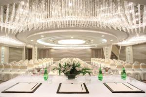 乌代浦乌代布尔丽筠酒店的一个带白色椅子和大吊灯的宴会厅