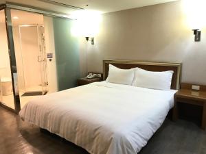 东港大鹏湾度假酒店的卧室配有一张带白色床单和枕头的大床。