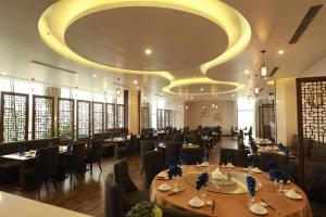 清化Central Hotel Thanh Hoa的一间带桌椅的用餐室和大型天花板