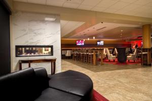 德梅因Holiday Inn Des Moines-Airport Conf Center, an IHG Hotel的酒店大堂设有壁炉和酒吧