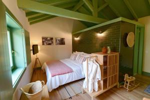 阿马兰特Vila Coura的一间卧室设有一张床和砖墙