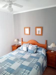 罗塔APARTAMENTO ROTEÑO CERCA DEL MAR的一间卧室配有蓝色和白色的床以及2个床头柜
