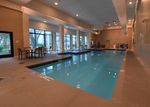 欧文Holiday Inn Irving Las Colinas, an IHG Hotel的一个带桌椅的房间的大型游泳池