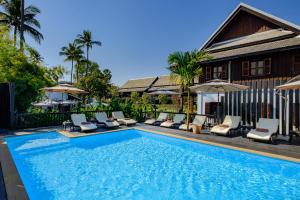 琅勃拉邦琅勃拉邦保护区酒店的一个带躺椅的游泳池以及一座房子