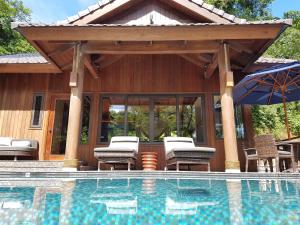科罗尔帕劳太平洋度假酒店的游泳池设有凉亭、椅子和遮阳伞