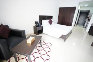 拉斯阿尔卡麦Aurak Guest House的一间卧室配有一张床、一张桌子和一张沙发