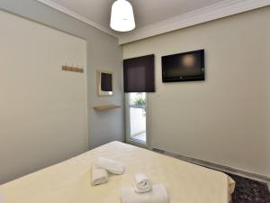 弗洛伊塔3S Apartments Nea Flogita Halkidiki的卧室配有一张床,墙上配有电视。