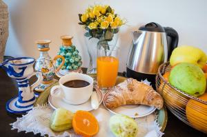 锡拉库扎Masseria Testaferrata的一张早餐桌,包括一杯咖啡和一篮水果