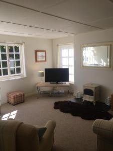 特鲁罗The Thatched Cottage的客厅配有平面电视和沙发。
