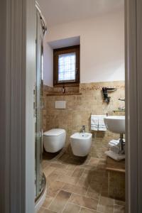 MontefortinoB&B Terra di Marca的一间带两个盥洗盆、浴缸和卫生间的浴室