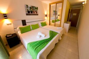 圣马丁德拉韦加Hostal San Marcos的酒店客房,配有两张带绿床单的床