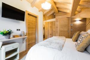 蒙特里永Chalet sur les monts Morzine的卧室配有白色的床和平面电视。