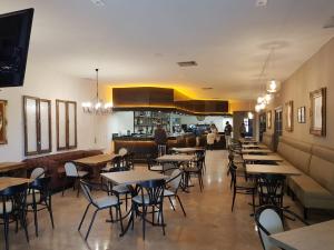 埃尔托沃索Hostal Restaurante Dulcinea de El Toboso的一间带桌椅的餐厅和一间酒吧