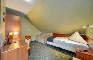 卡尔帕奇Hotel Belweder - przy hotelu Golebiewski的小房间设有一张床、一张桌子和一张床。