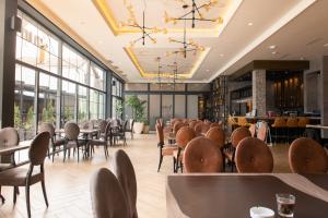 贝尔格莱德Hotel Nota的用餐室设有桌椅和窗户。