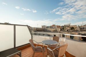 巴塞罗那巴塞罗那阿拉姆特公寓酒店的阳台的天井配有桌椅