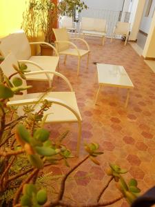 莫格尔埃斯科里巴诺广场酒店的一间设有白色桌椅的房间和植物