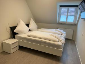 格尔梅斯海姆Hotel Quartier 8的一张带白色枕头的小床和窗户
