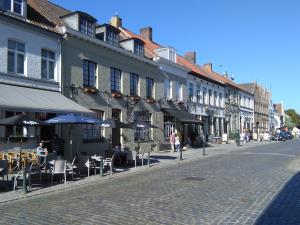 达默Gasthof Maerlant的一条鹅卵石街道,设有桌椅和建筑