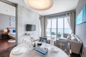 纳仲天Mövenpick Residence/Beach Access/2BR/Luxury Stay的一间带桌子的客厅和一间带沙发的房间