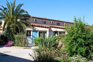 圣西普里安Lagrange Grand Bleu Vacances – Résidence Les Jardins de Neptune的棕榈树和一些植物的房子