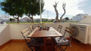 圣卢西亚岛Dream holidays @ Santa Luzia Tavira的阳台上配有木桌和椅子,阳台上配有加热器