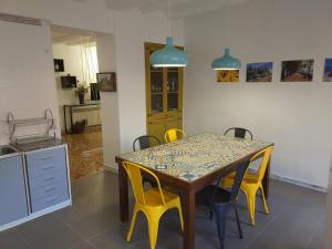 CretasCasa Mineta的餐桌、黄色椅子和厨房