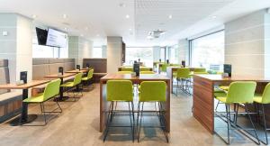 纽伦堡第一酒店的一间设有绿色椅子和桌子的等候室