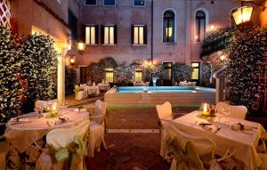 威尼斯乔尔乔涅酒店的一间设有白色桌子和游泳池的餐厅