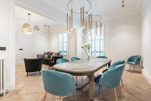 巴塞罗那Weflating City Center的一间带桌子和蓝色椅子的用餐室