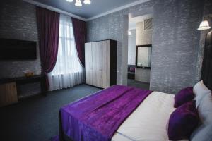 伊兹梅尔Отель БЕССАРАБИЯ的一间卧室配有一张带紫色毯子的床