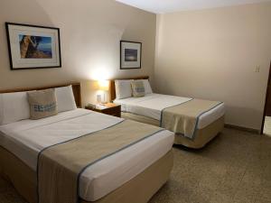 圣胡安Canario Lagoon Hotel的一间酒店客房,房间内设有两张床