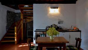 考波尔奇Kapolcs Cottage的厨房配有桌子、炉灶和楼梯。