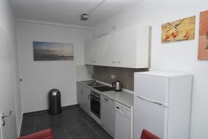 盖尔森基兴City Apartment Vohwinkel的厨房配有白色橱柜和冰箱。