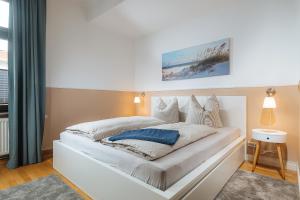 罗斯托克Große Koje mit Terrasse的卧室配有白色床和蓝色枕头