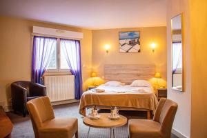 索姆河畔的圣瓦列里杜伯特德斯贝恩酒店的酒店客房,配有一张床和两把椅子