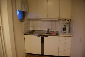 韦灵厄韦林格胡斯酒店的小厨房配有白色橱柜和水槽