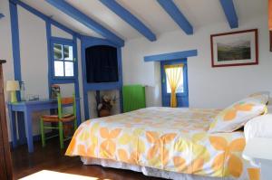 康博莱班Domaine Xixtaberri的蓝色和白色的卧室配有一张床和一张书桌