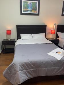 特鲁希略ORBEGOSO - Trujillo的一间卧室配有一张带两盏灯的大型白色床。