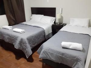 特鲁希略ORBEGOSO - Trujillo的两张位于酒店客房的床,配有毛巾